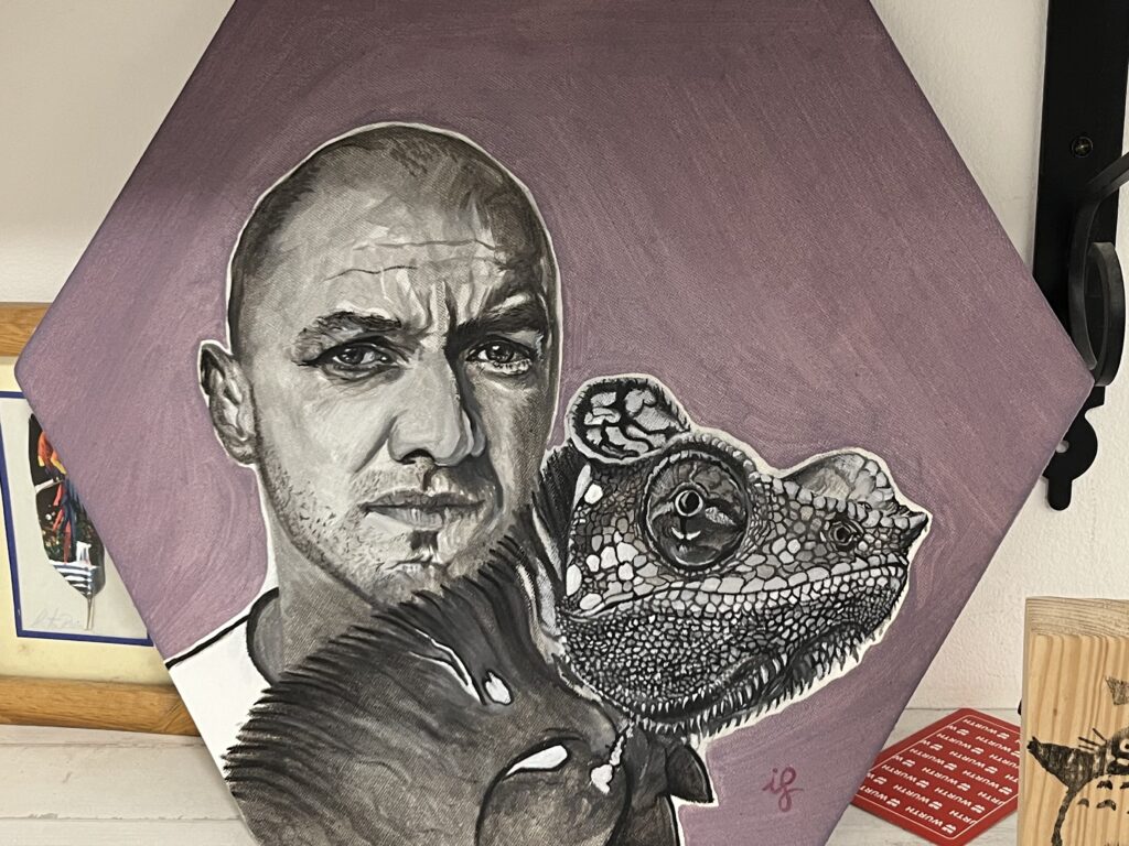 Pintura sobre tela hexagonal lila amb un home i un camaleó, obra d'Ifgasa
